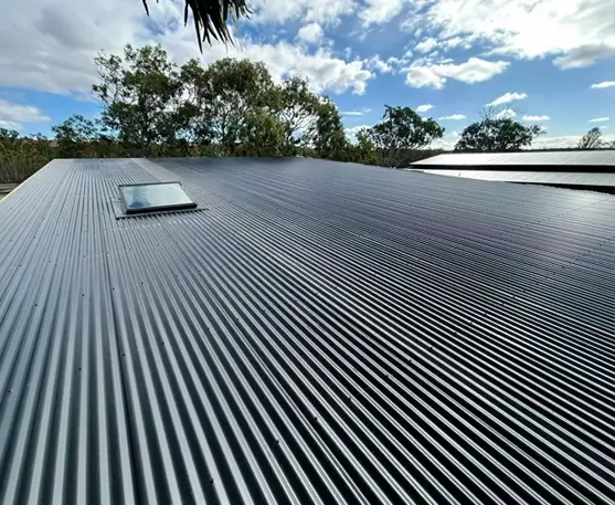 DN Roofing & Restoration homepage image of a re-roofing project, an image of a dark grey corrugated tin roof with a skylight.